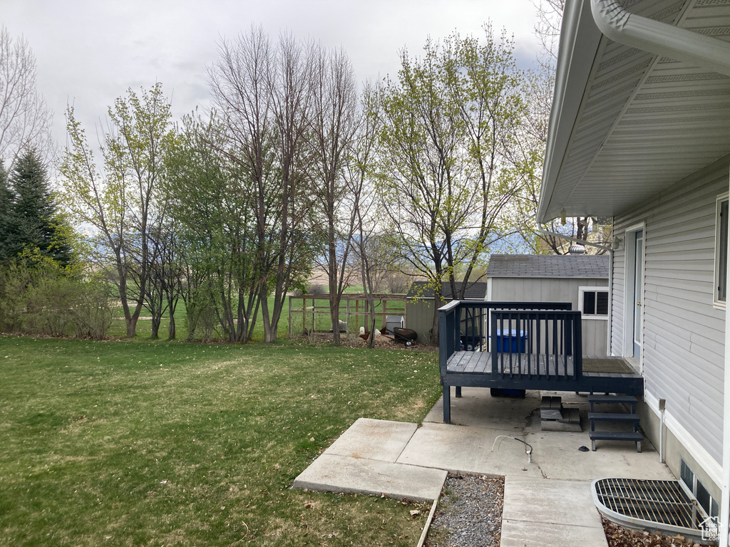 View of yard with a patio, fence, and a deck