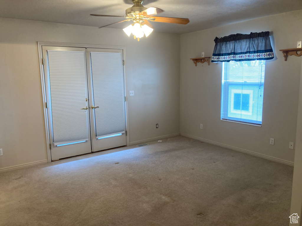 Unfurnished room with baseboards, a ceiling fan, and carpet floors