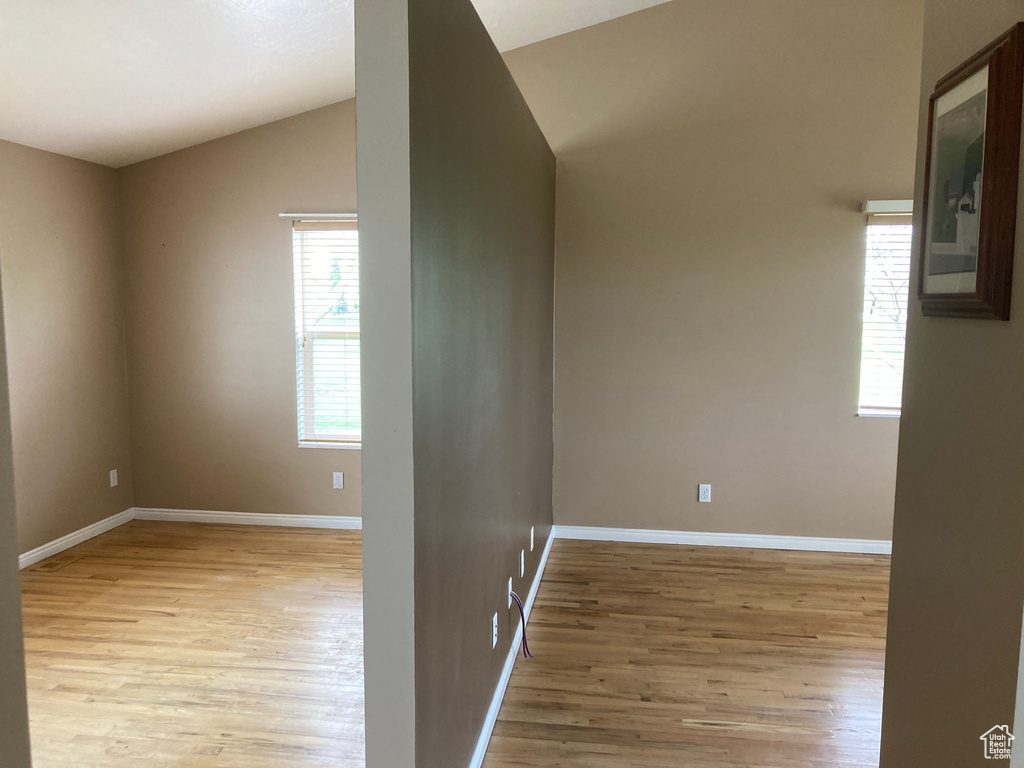 Interior space featuring baseboards, vaulted ceiling, and wood finished floors