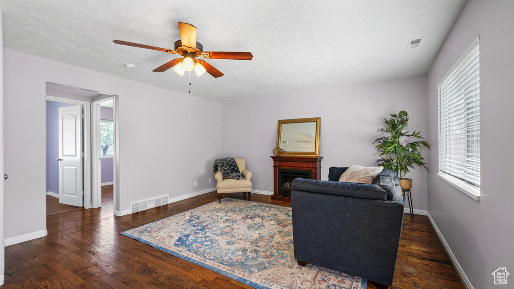 Living area featuring wood finished floors, ceiling fan, and visible vents