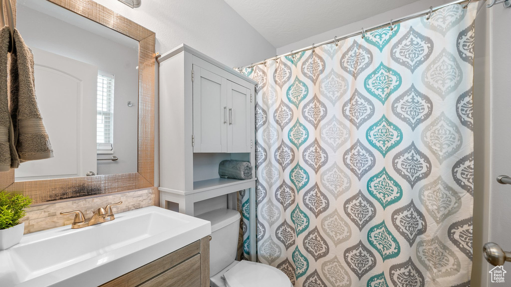 Bathroom with backsplash, toilet, and vanity