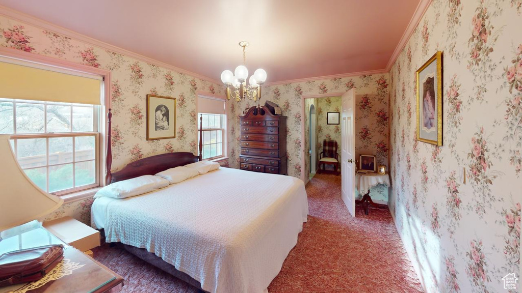 Bedroom featuring a notable chandelier, ornamental molding, and carpet floors