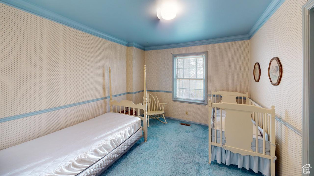 Carpeted bedroom with ornamental molding