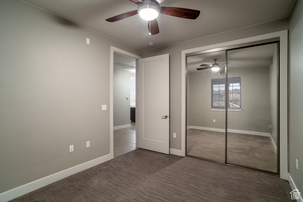 Unfurnished bedroom with a closet, ceiling fan, baseboards, and carpet