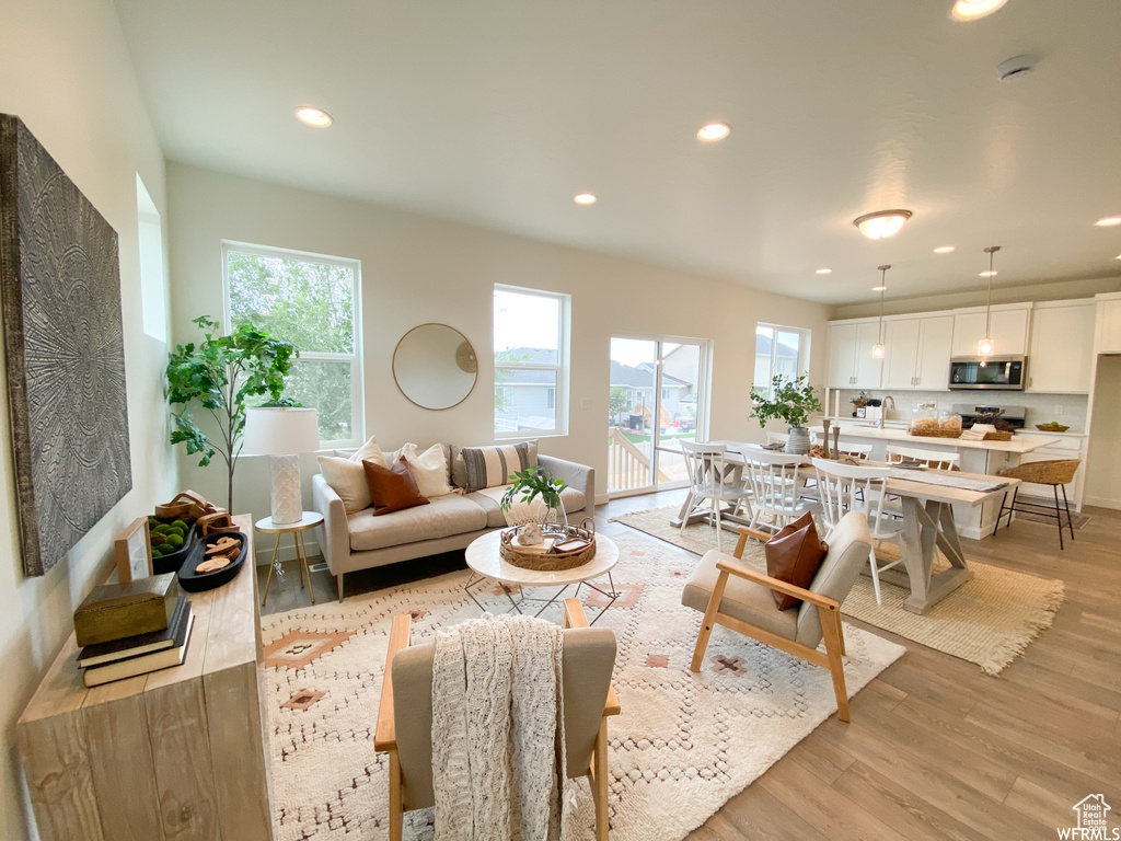 Living room featuring light wood-type flooring, a healthy amount of sunlight, and recessed lighting