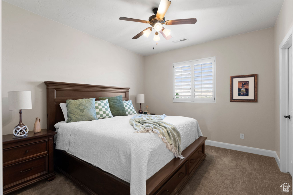 Carpeted bedroom featuring visible vents, baseboards, and a ceiling fan