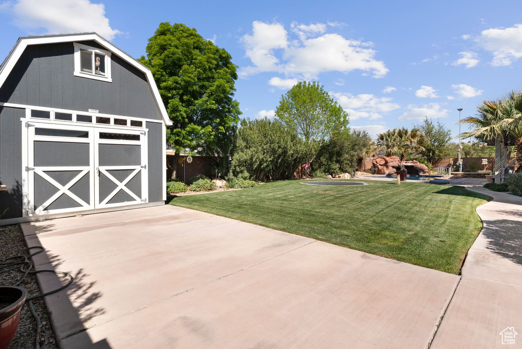 View of yard with an outdoor structure and a storage unit