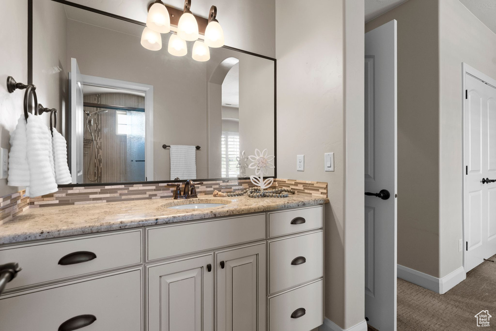 Full bathroom with backsplash, baseboards, and vanity