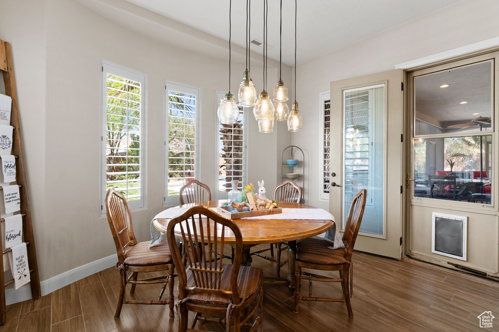 Dining space with a healthy amount of sunlight, baseboards, and wood finished floors