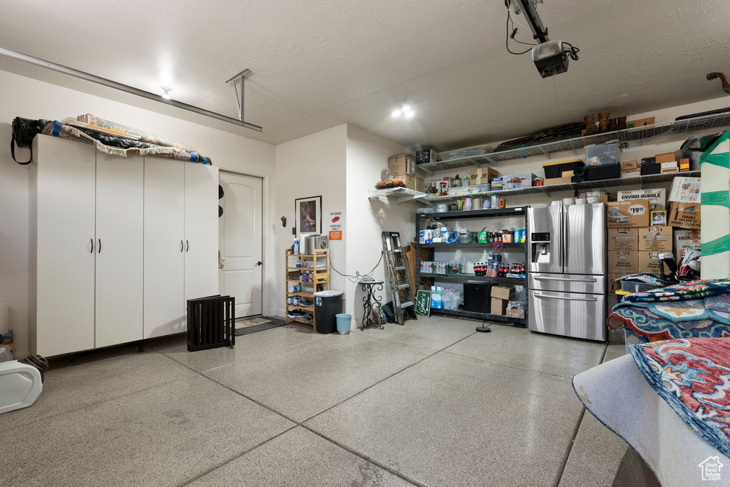 Garage with a garage door opener and stainless steel fridge