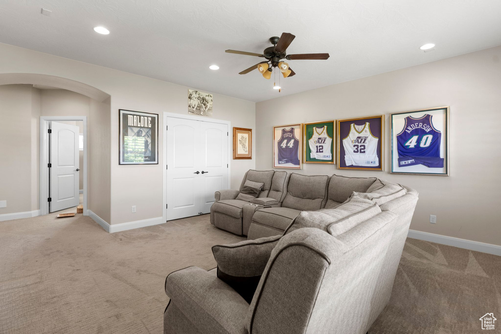 Living room featuring ceiling fan, arched walkways, recessed lighting, light carpet, and baseboards