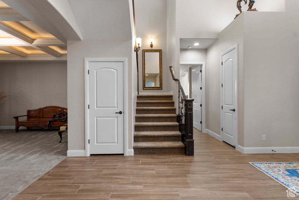 Foyer featuring light wood-style flooring, baseboards, and stairway