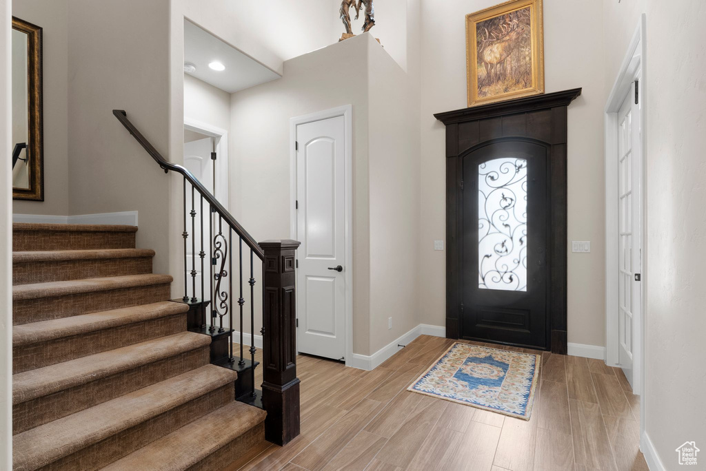 Entryway with stairway, recessed lighting, light wood finished floors, and baseboards