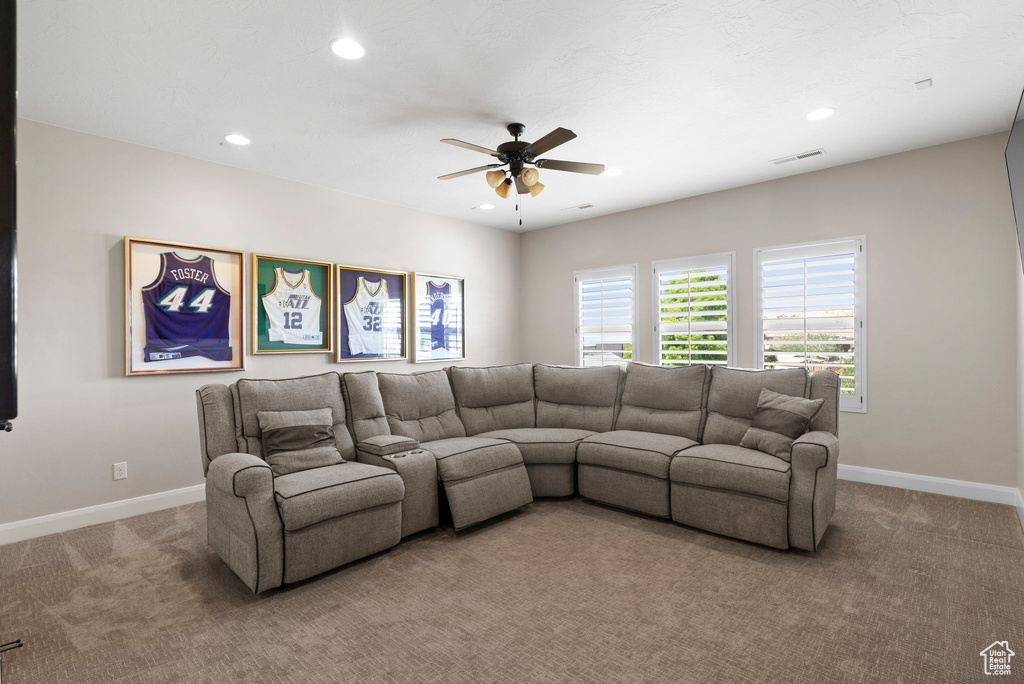 Living area with visible vents, baseboards, a ceiling fan, and light colored carpet