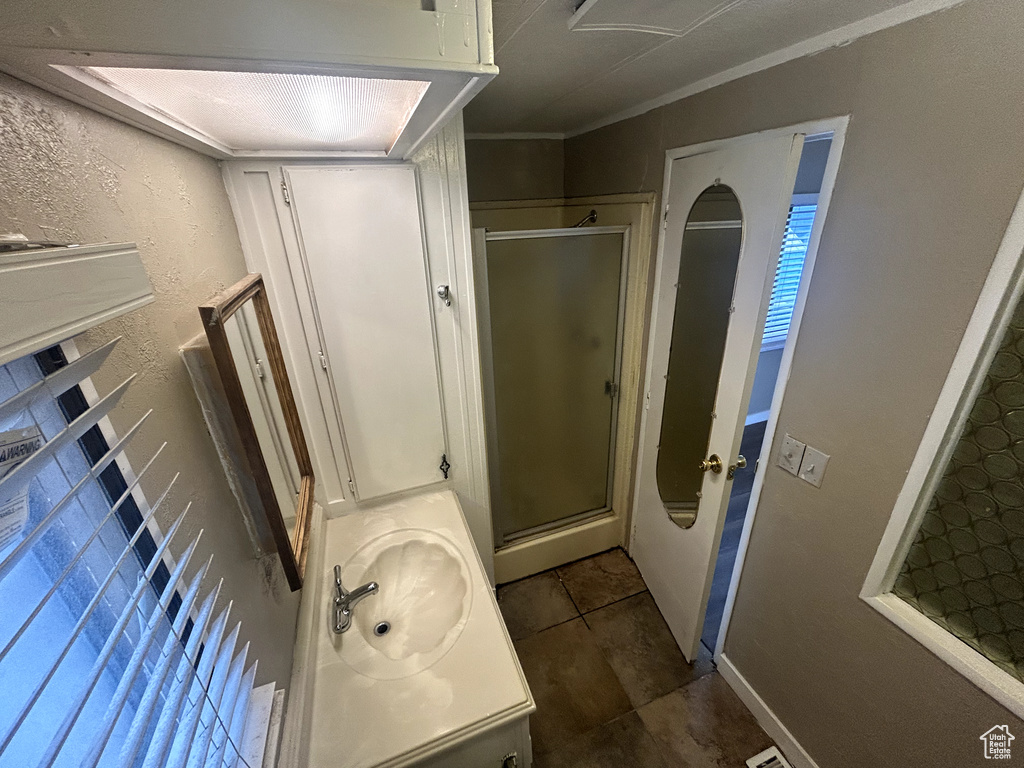 Full bath featuring baseboards, a shower stall, and vanity