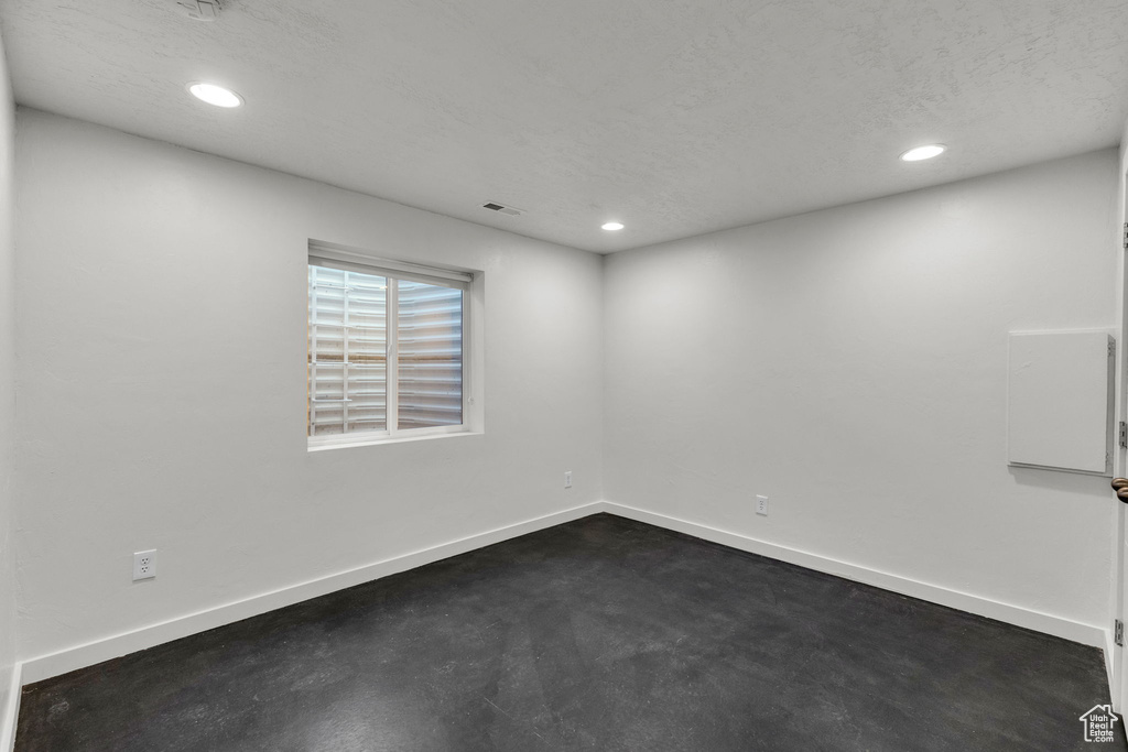 Unfurnished room with recessed lighting, baseboards, and a textured ceiling