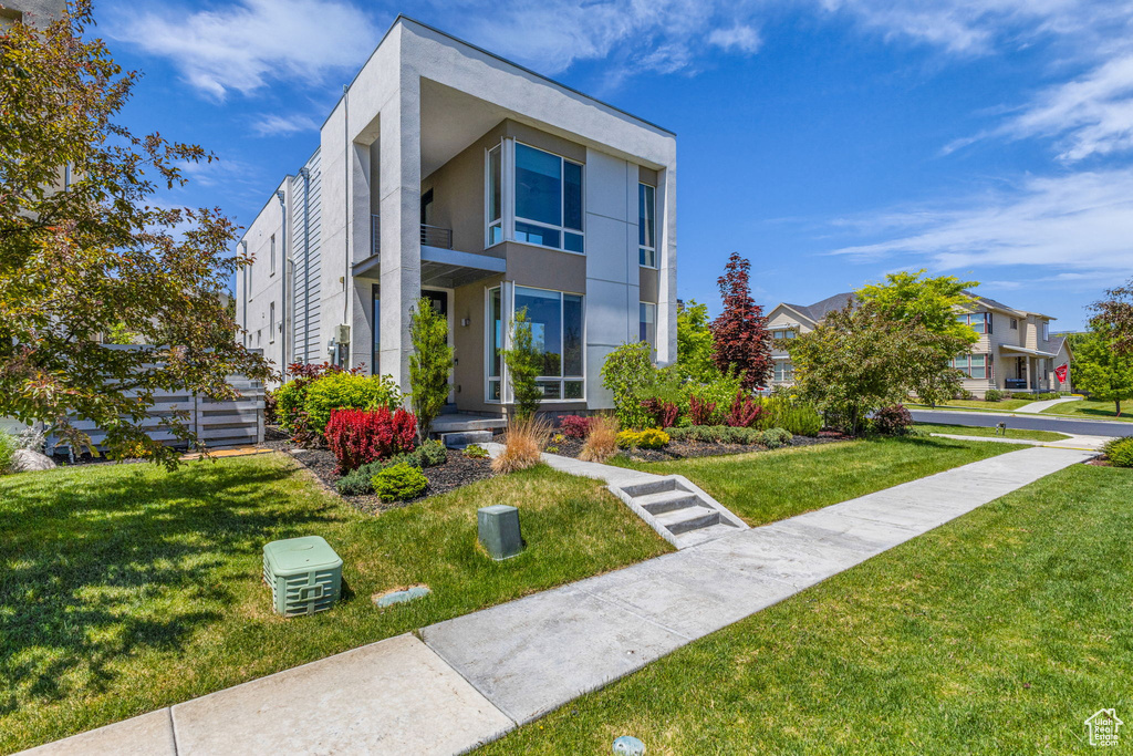 Modern home featuring stucco siding and a front yard