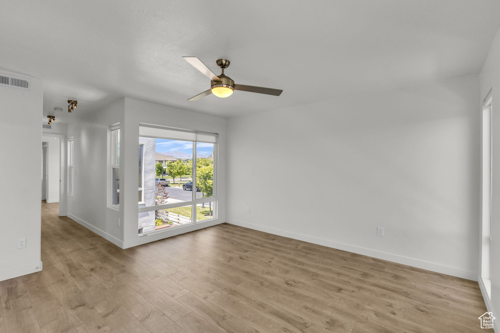 Unfurnished room featuring light wood-style flooring, baseboards, and ceiling fan