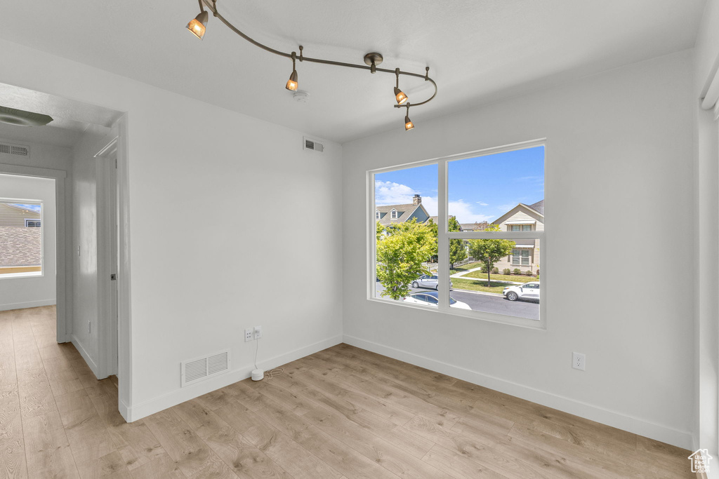 Spare room with baseboards and light wood-type flooring