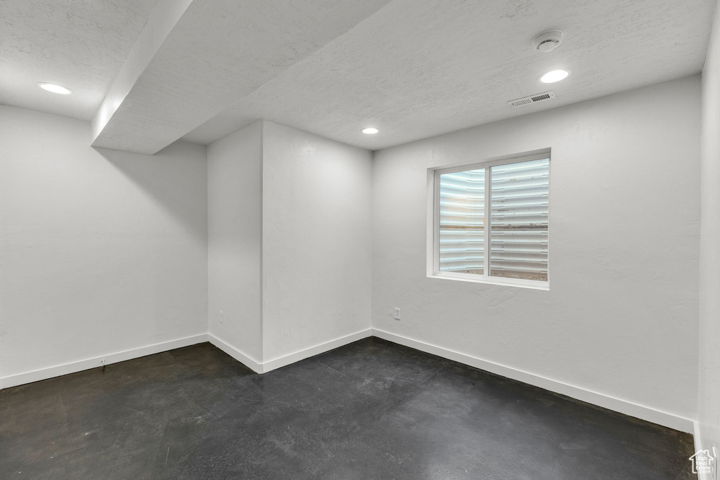 Basement featuring a textured ceiling, baseboards, and recessed lighting