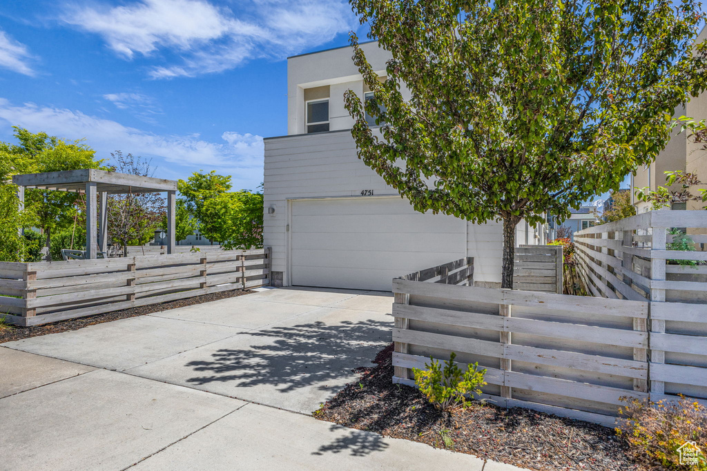View of side of property featuring concrete driveway and an attached garage