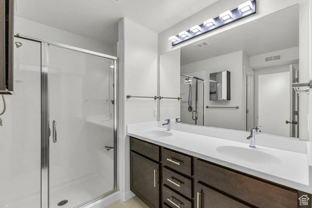 Full bathroom with a shower stall and double vanity