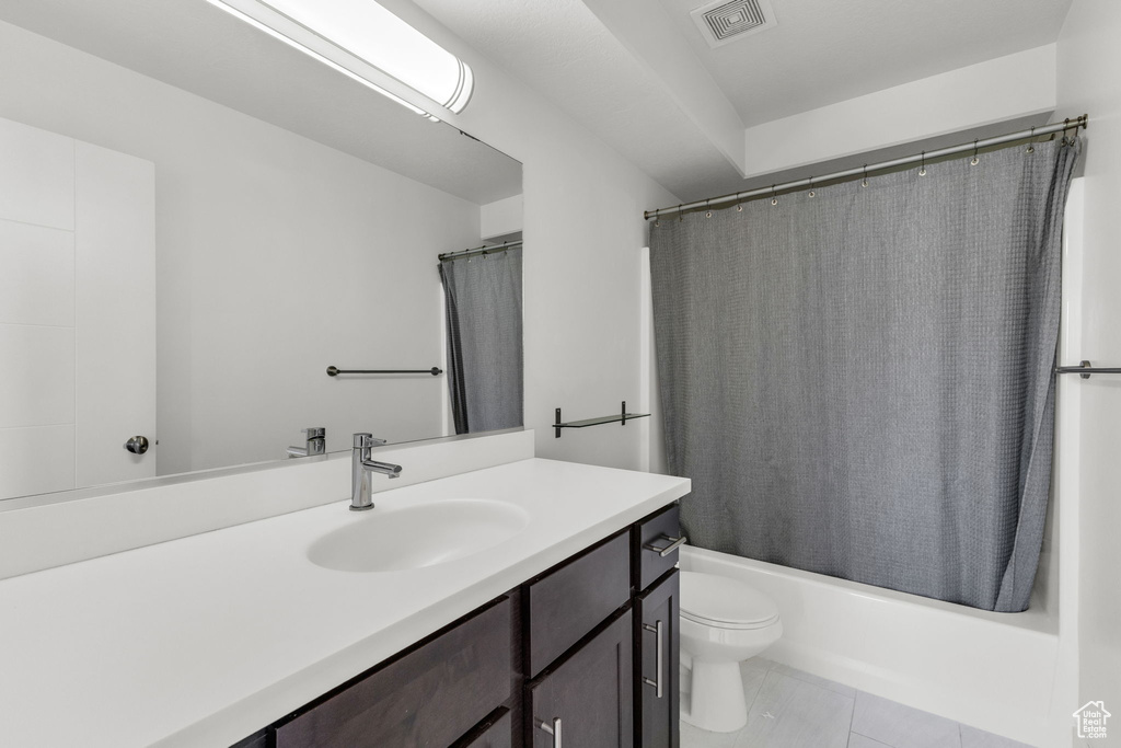 Full bathroom featuring vanity, toilet, shower / bath combo, and tile patterned flooring