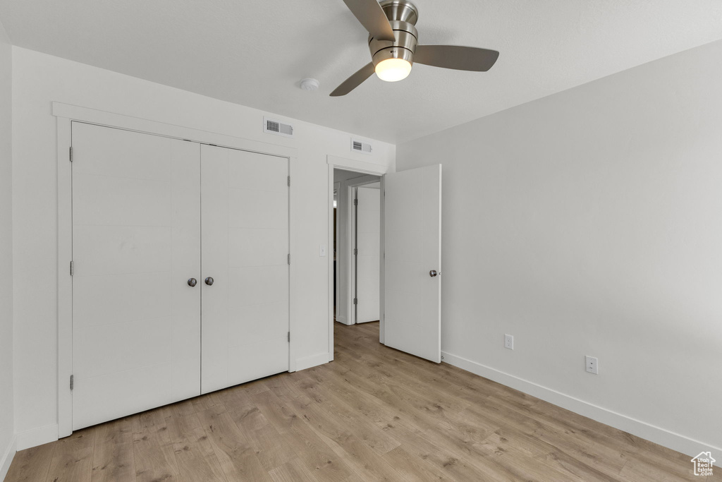 Unfurnished bedroom featuring baseboards, light wood finished floors, a closet, and ceiling fan