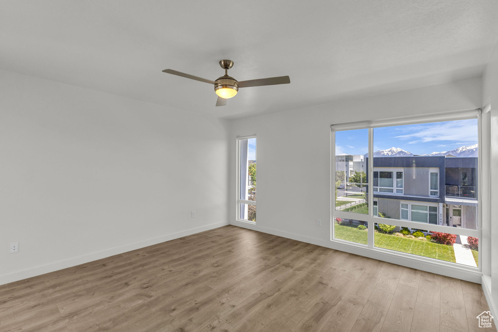 Spare room featuring wood finished floors, baseboards, and a ceiling fan