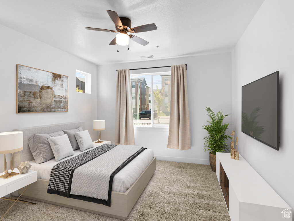 Carpeted bedroom featuring visible vents, baseboards, and ceiling fan