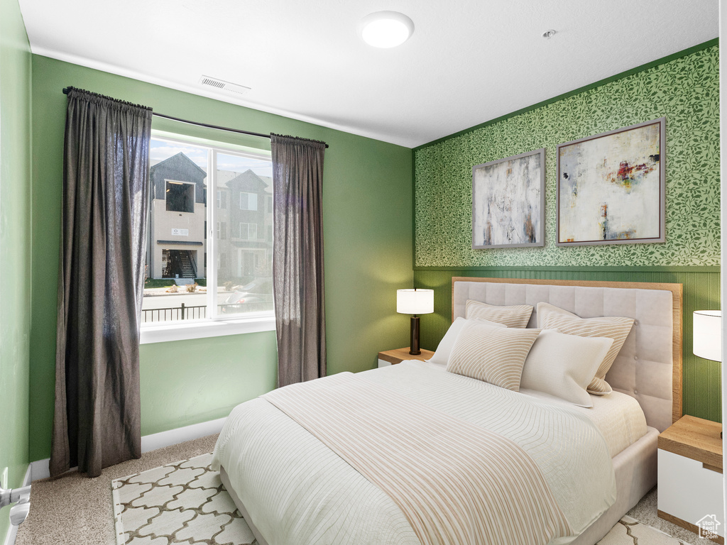 Carpeted bedroom with wallpapered walls, baseboards, and visible vents