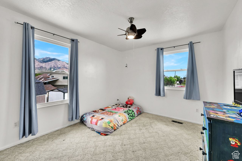 Bedroom featuring carpet, a textured ceiling, baseboards, and a ceiling fan