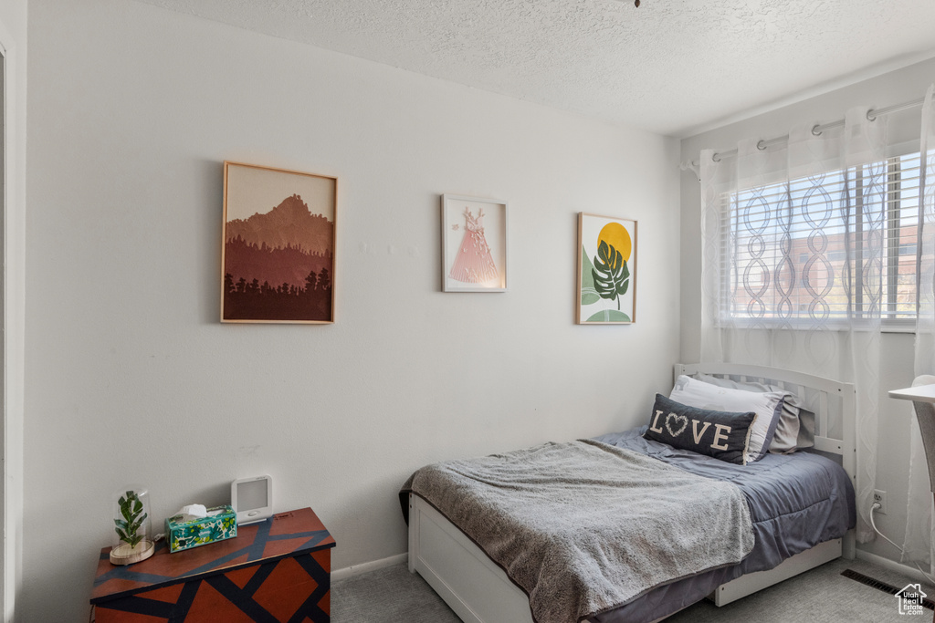 Bedroom with carpet flooring and a textured ceiling