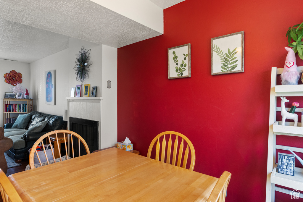 Dining room with a fireplace and a textured ceiling
