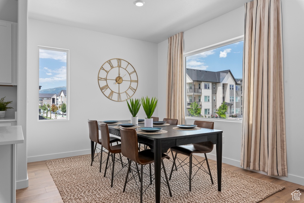 Dining room featuring visible vents, light wood-type flooring, and baseboards