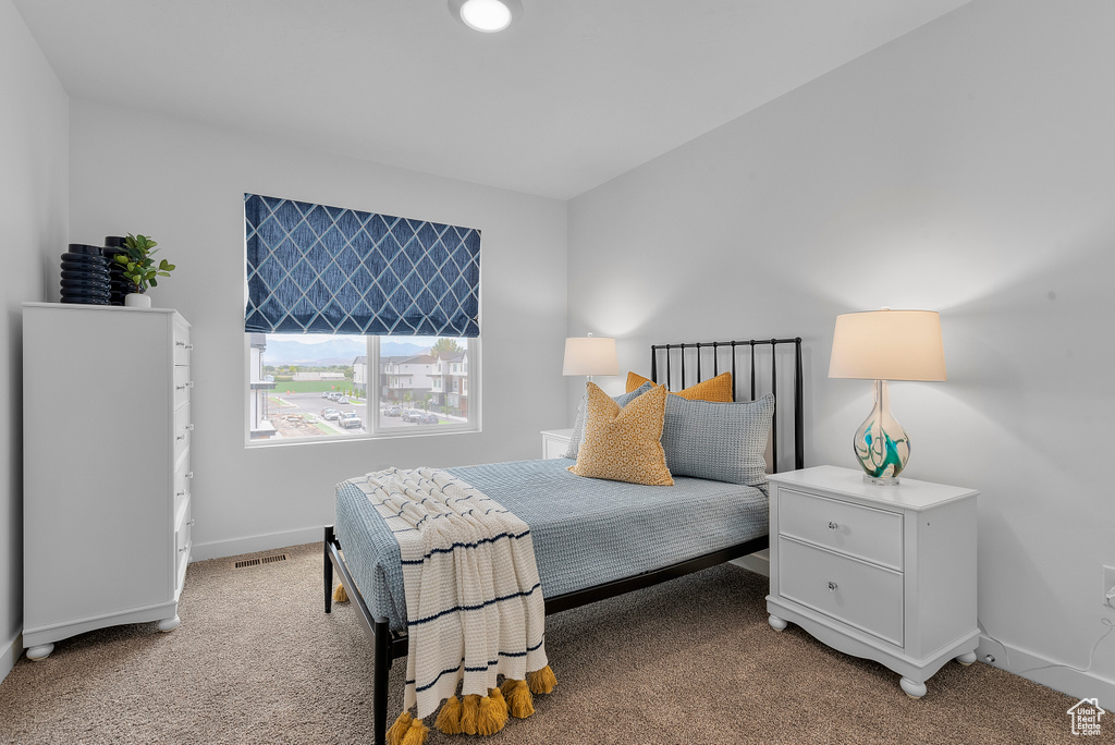 Bedroom featuring visible vents, baseboards, and light carpet
