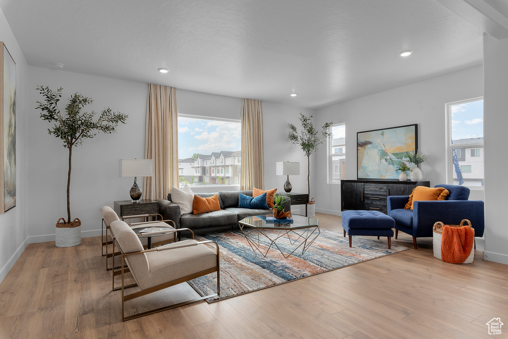 Living area with baseboards, recessed lighting, and light wood-style floors