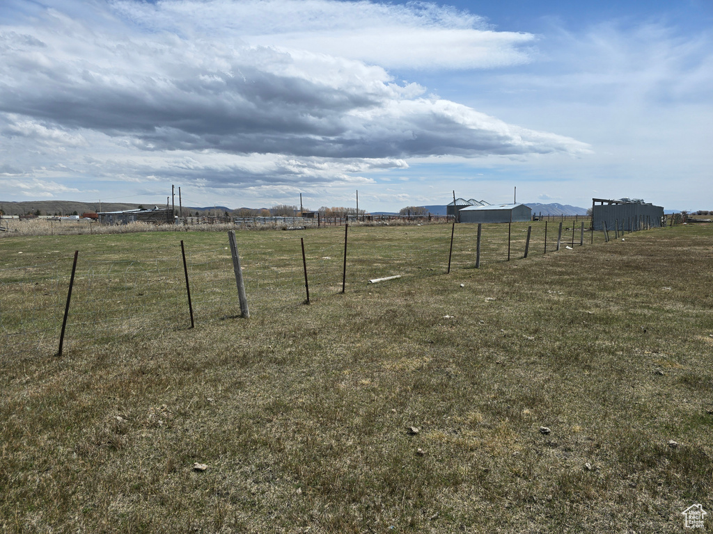 View of yard featuring a rural view and fence