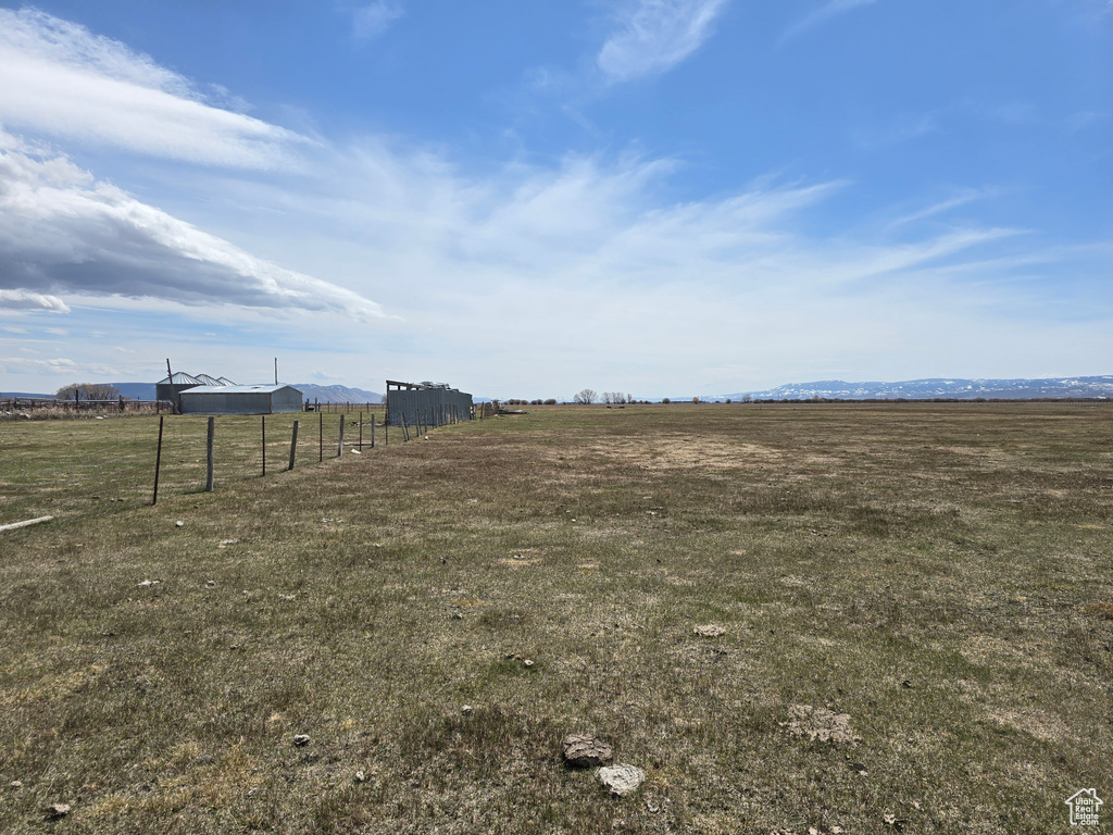 View of yard with fence and a rural view