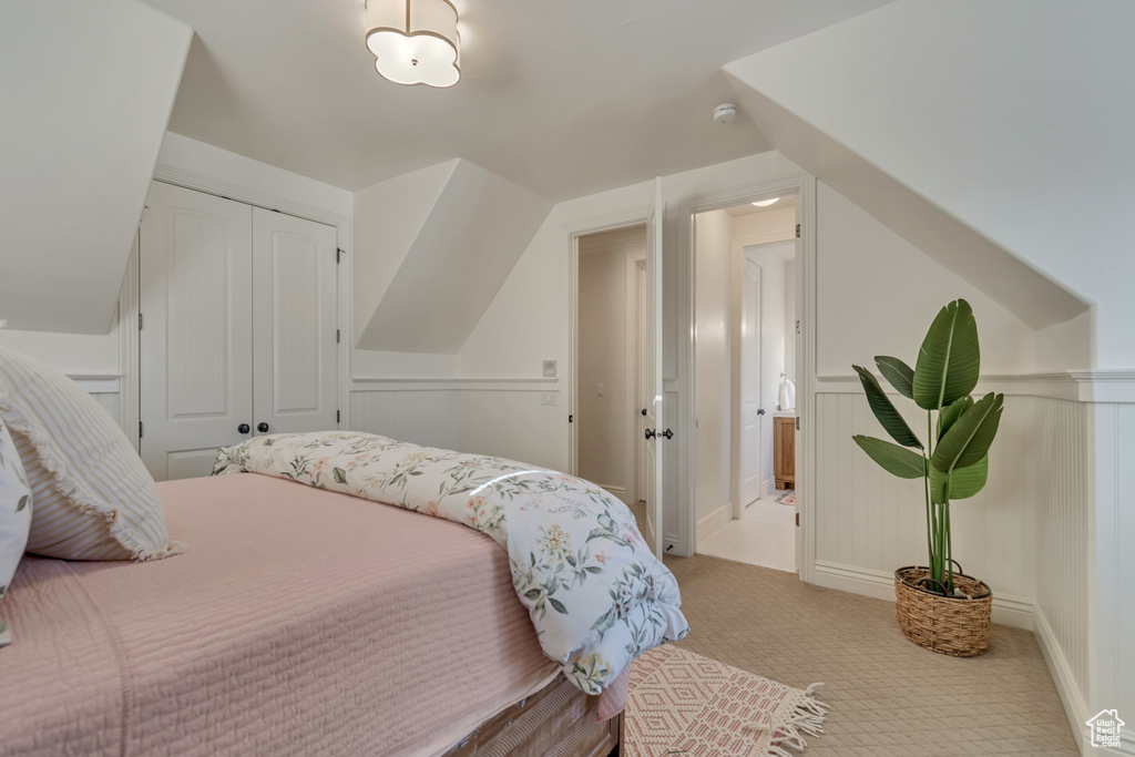 Carpeted bedroom featuring a closet and lofted ceiling