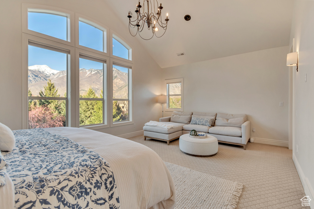 Carpeted bedroom featuring a mountain view, baseboards, multiple windows, and an inviting chandelier