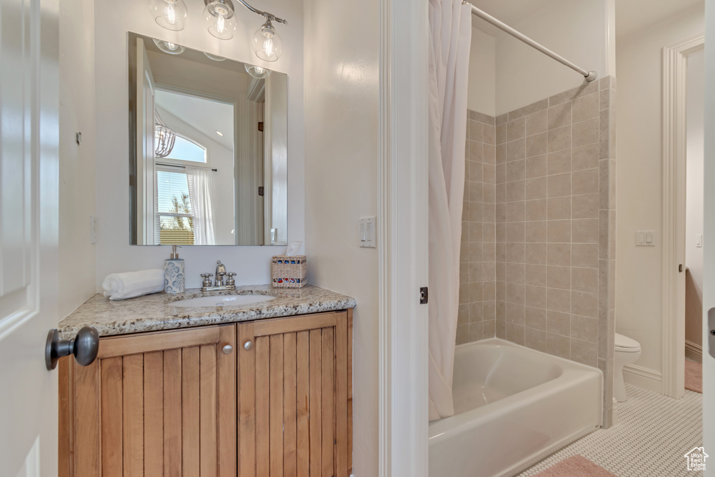Full bathroom with tile patterned floors, toilet, shower / bathtub combination with curtain, and vanity