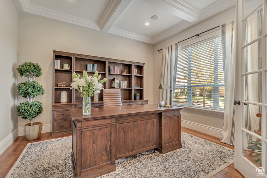 Home office featuring ornamental molding, coffered ceiling, light wood finished floors, baseboards, and beam ceiling