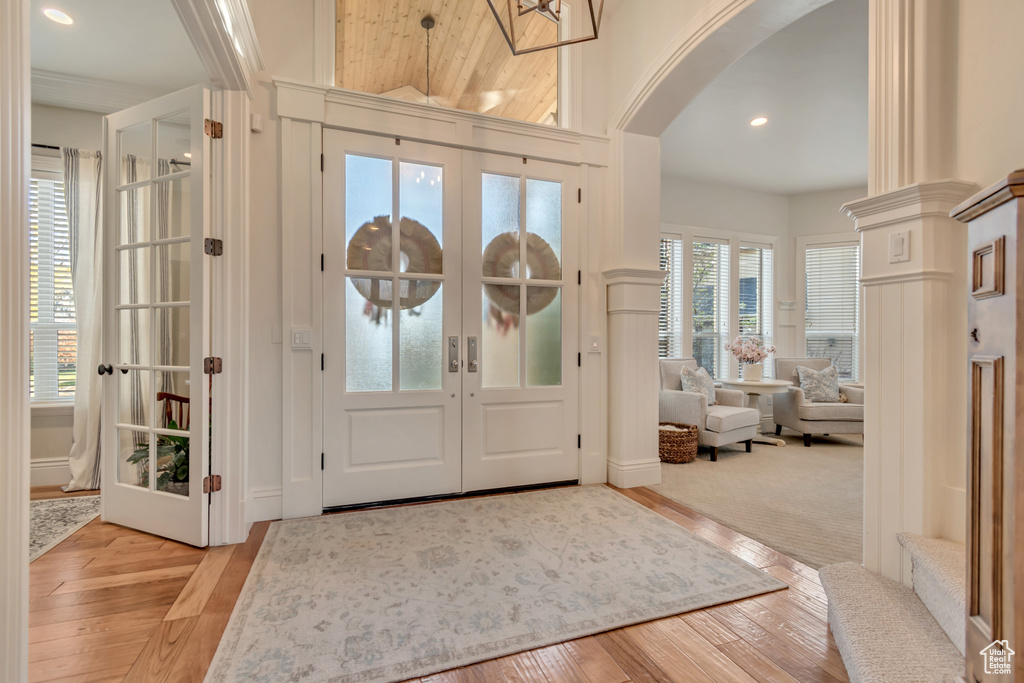 Entryway with arched walkways, french doors, recessed lighting, and hardwood / wood-style flooring
