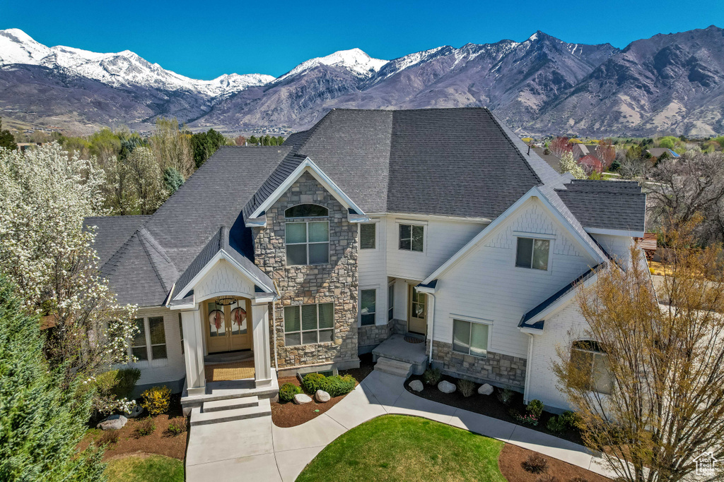 Craftsman inspired home featuring a mountain view, french doors, a shingled roof, and stone siding