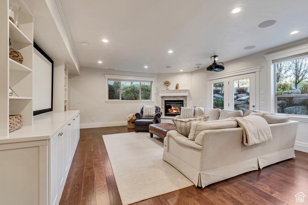 Living room featuring dark wood-type flooring, baseboards, recessed lighting, and plenty of natural light