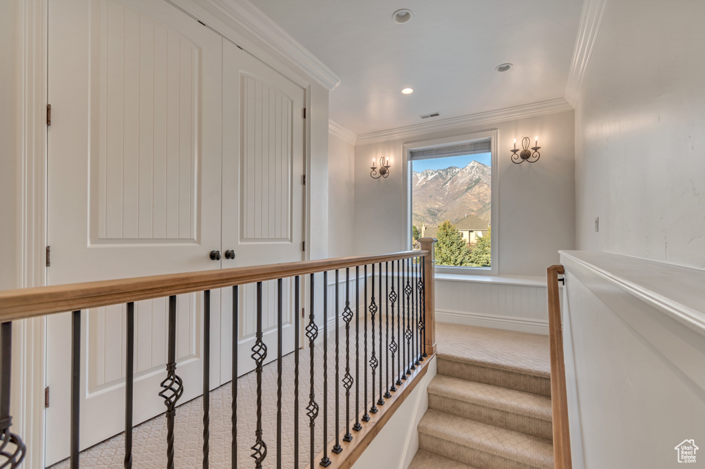 Stairs with ornamental molding, carpet floors, and visible vents
