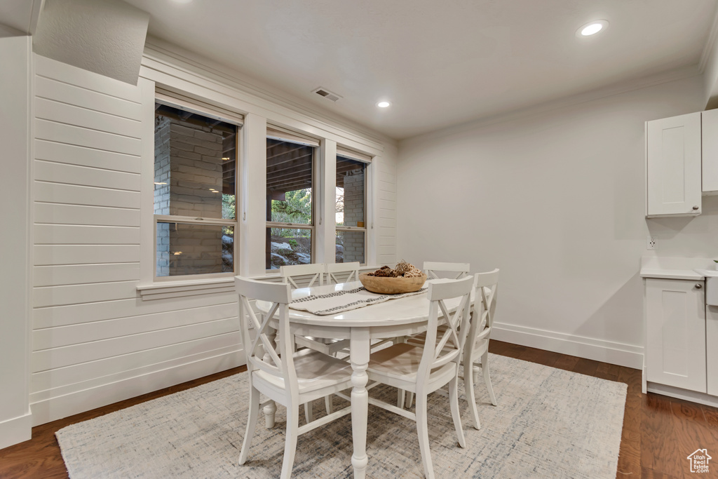 Dining space featuring dark wood-style flooring, recessed lighting, visible vents, and baseboards