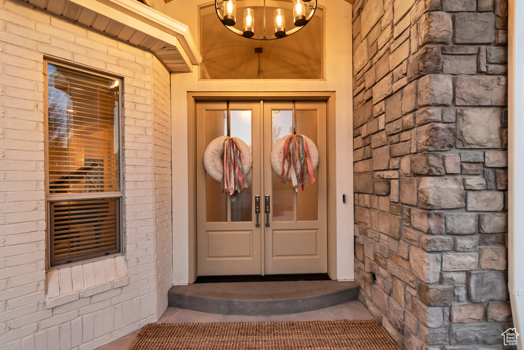 Property entrance featuring french doors and brick siding