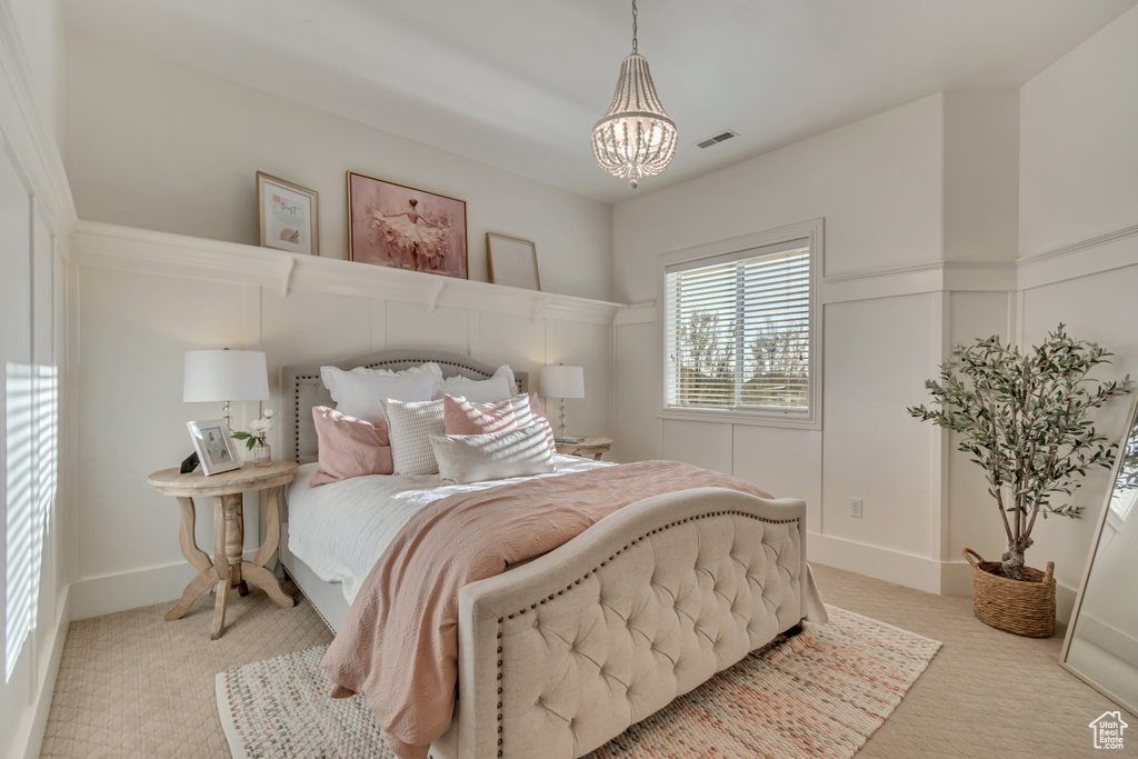 Carpeted bedroom with a notable chandelier and visible vents